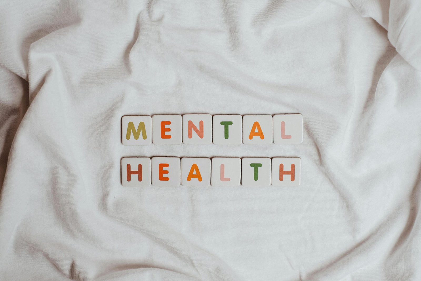 Close-up of 'Mental Health' text on cloth, symbolizing calmness and self-care.